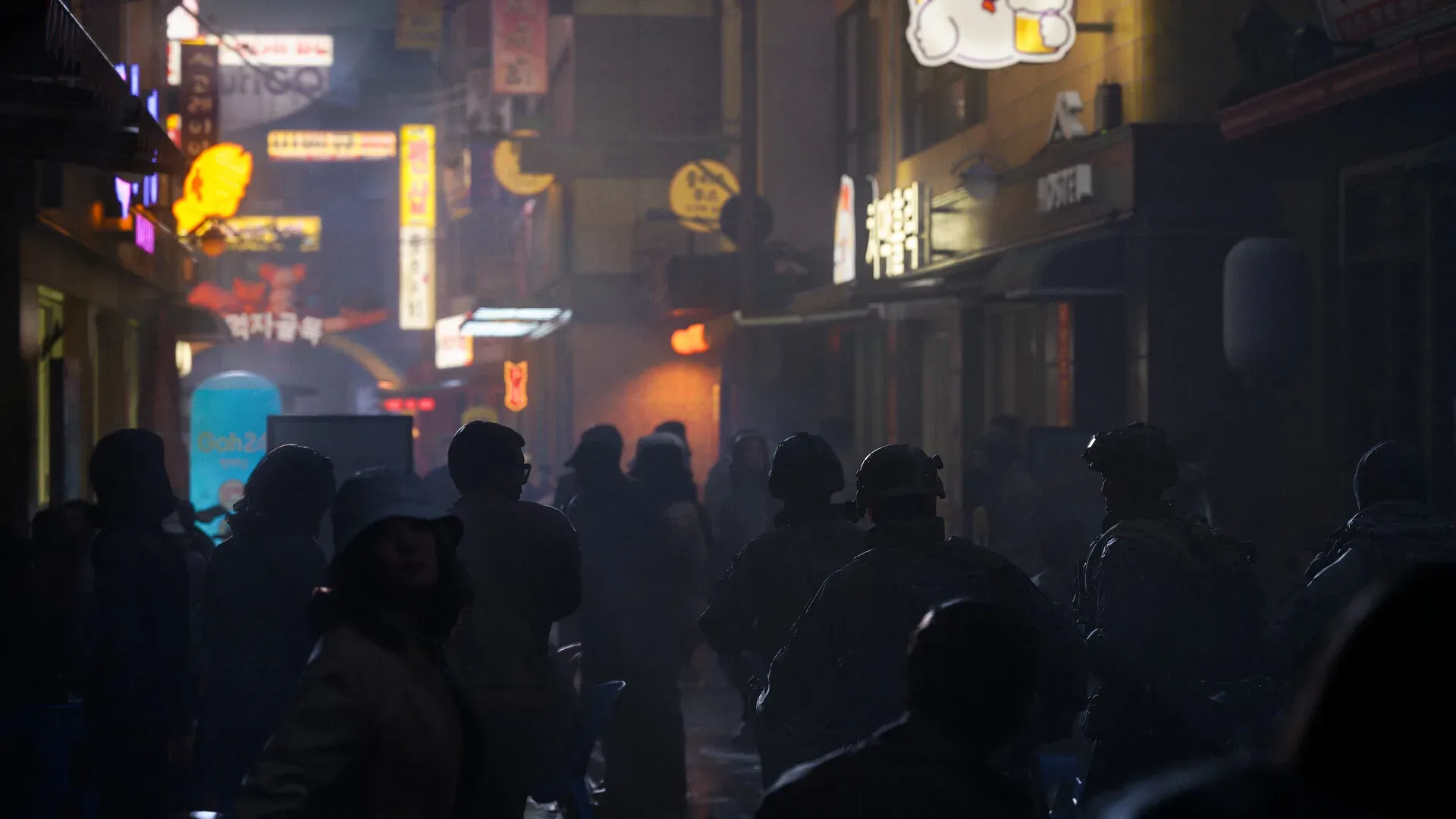 Operatives moving through a glowing night-time shopping street