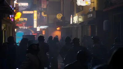 Operatives moving through a glowing night-time shopping street