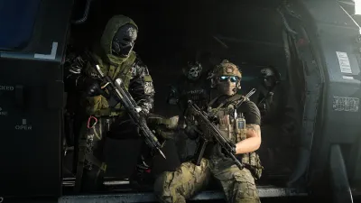 Two soldiers with weapons drawn inside a darkened vehicle bay